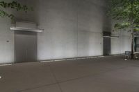 this is a concrete building with many trees and two elevator doors to the right of the door