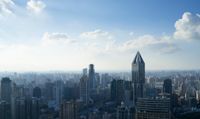 a city with many buildings and skyscrapers on a sunny day with a blue sky