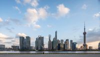 the large body of water has a few yellow barriers at it's sides and a city skyline is in the background