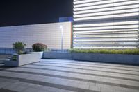 the patio with plants sits next to the wall on the side of a building with steps leading up