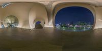 the curved walls of the museum show off different views of the city at night as well as the buildings