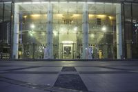 a large glass building with several windows and lots of lights on it's front