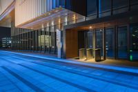 street with illuminated traffic lights and glass doors and sidewalk at night time in tokyo, japan