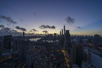 cityscape in evening time from the top of an observation tower with clouds and sun setting