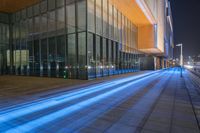 a long exposure photo of the buildings lit up at night with bright blue light streaks