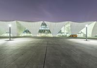 there is a white structure in the middle of a building that has an entrance and a lot of windows