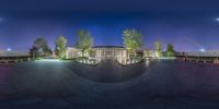 this image shows the view of an empty skateboard park from below, with a night sky and trees surrounding