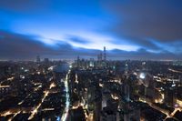 a boat is traveling through a large river next to the city of shanghai, china