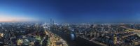 an aerial view of a city at dusk from a highrise building on the corner