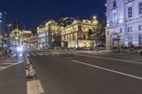 an empty city street at night with traffic lights on and a building across the street