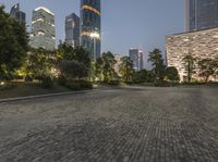 a cityscape with a clock tower stands in an empty park at night in shanghai