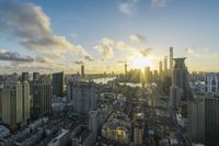 the sun sets behind the skyline of urban buildings on a busy day in the city