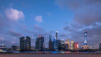 a view of a city with tall buildings in the background at dusk with a dark sky