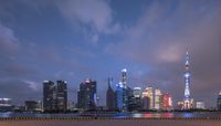 a view of a city with tall buildings in the background at dusk with a dark sky