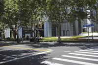 the sidewalk outside of an office building with people walking and sitting on benches in the grass