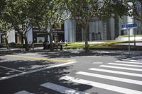 the sidewalk outside of an office building with people walking and sitting on benches in the grass