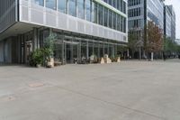 two men walking out of an office building on a clear day out front, some buildings are behind them