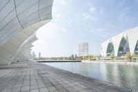 the buildings are all white against a blue sky day time view of a body of water