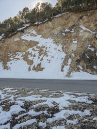 a person is standing near the side of the mountain while riding on his skateboard