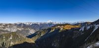 a cable going down into the mountains with mountains in the background and blue sky behind