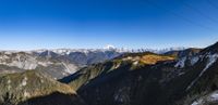 a cable going down into the mountains with mountains in the background and blue sky behind