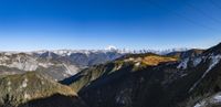 a cable going down into the mountains with mountains in the background and blue sky behind