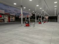 the interior of a shell gas station lit up with red lights and red gasoline pumps