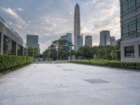 an empty courtyard that is very empty with trees and buildings in the background on a cloudy day