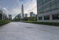 an empty courtyard that is very empty with trees and buildings in the background on a cloudy day