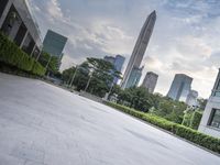 an empty courtyard that is very empty with trees and buildings in the background on a cloudy day