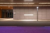 an empty parking garage is illuminated in a purple light on a city street at night