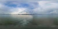 this is a picture of a cloudy day on the water and water level, with buildings on both sides, bridge in distance