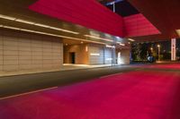 the red lights shine brightly as it passes through an entrance to a building at night