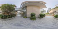 three identical panoramas of a hotel with circular planters on the sidewalk and some bushes