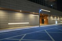 the exterior of a building with led lighting on a street corner at night in front of it