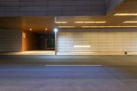 a city street with lights on in a dark room at night in the evening with a small building