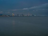 the water has very large chunks of blue in it and a skyline of large buildings in the background