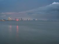 the water has very large chunks of blue in it and a skyline of large buildings in the background