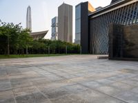 two buildings in the middle of a city park in front of some tall buildings in the background