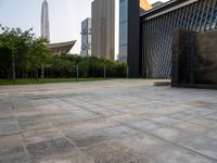 two buildings in the middle of a city park in front of some tall buildings in the background