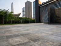 two buildings in the middle of a city park in front of some tall buildings in the background