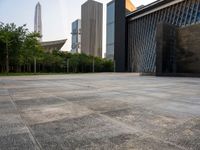 two buildings in the middle of a city park in front of some tall buildings in the background