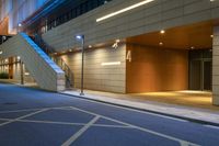 the entrance to an office building with stairs leading up to it at night in a city