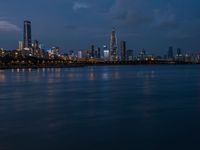 a cityscape seen from the shore of a river with a boat coming in