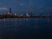 a cityscape seen from the shore of a river with a boat coming in