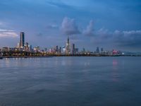 the water has very large chunks of blue in it and a skyline of large buildings in the background