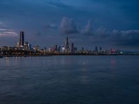 the water has very large chunks of blue in it and a skyline of large buildings in the background