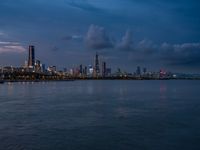 the water has very large chunks of blue in it and a skyline of large buildings in the background