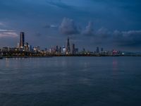 the water has very large chunks of blue in it and a skyline of large buildings in the background