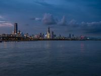 the water has very large chunks of blue in it and a skyline of large buildings in the background